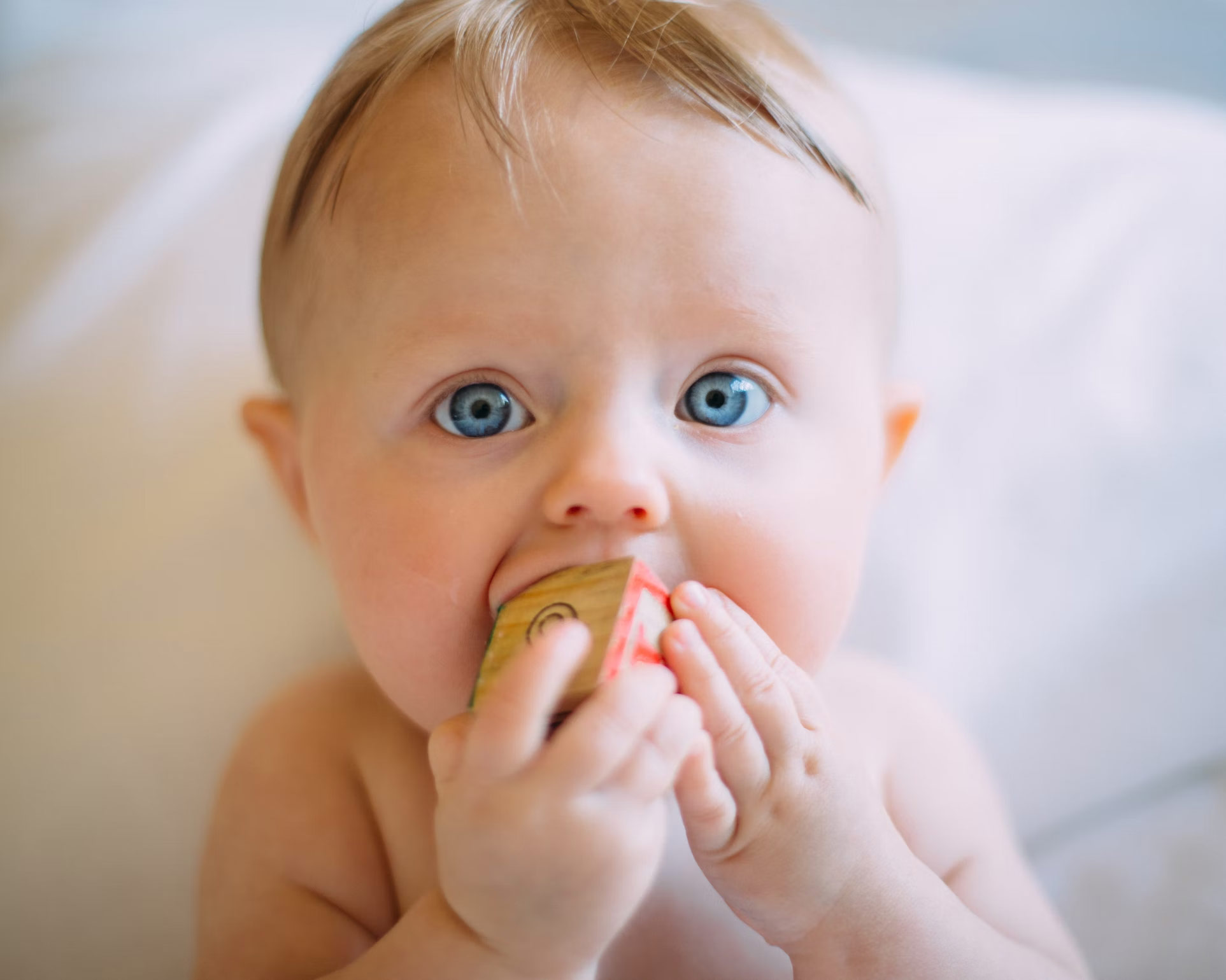 Baby som leker med en treklosse